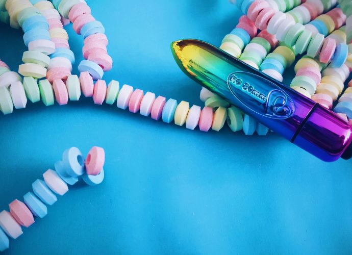 Feature photo for Rocks Off 80mm Bullet Vibrator review. Bullet laying over candy bra on a blue background.