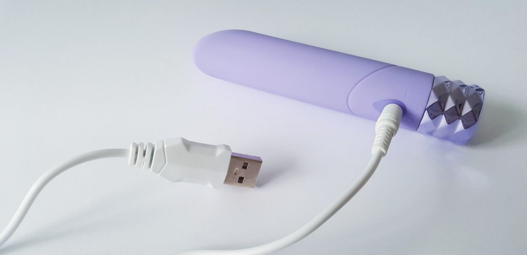 Image of the Maia Angel Crystal Gems Bullet Vibrator with white usb charging cable plugged into the side.