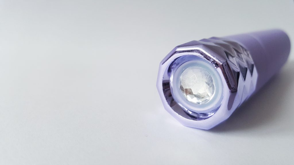 Close up image of the Maia Angel Crystal Gems Bullet Vibrator Button. A circular faux crystal gem button at the bottom of the vibrator.